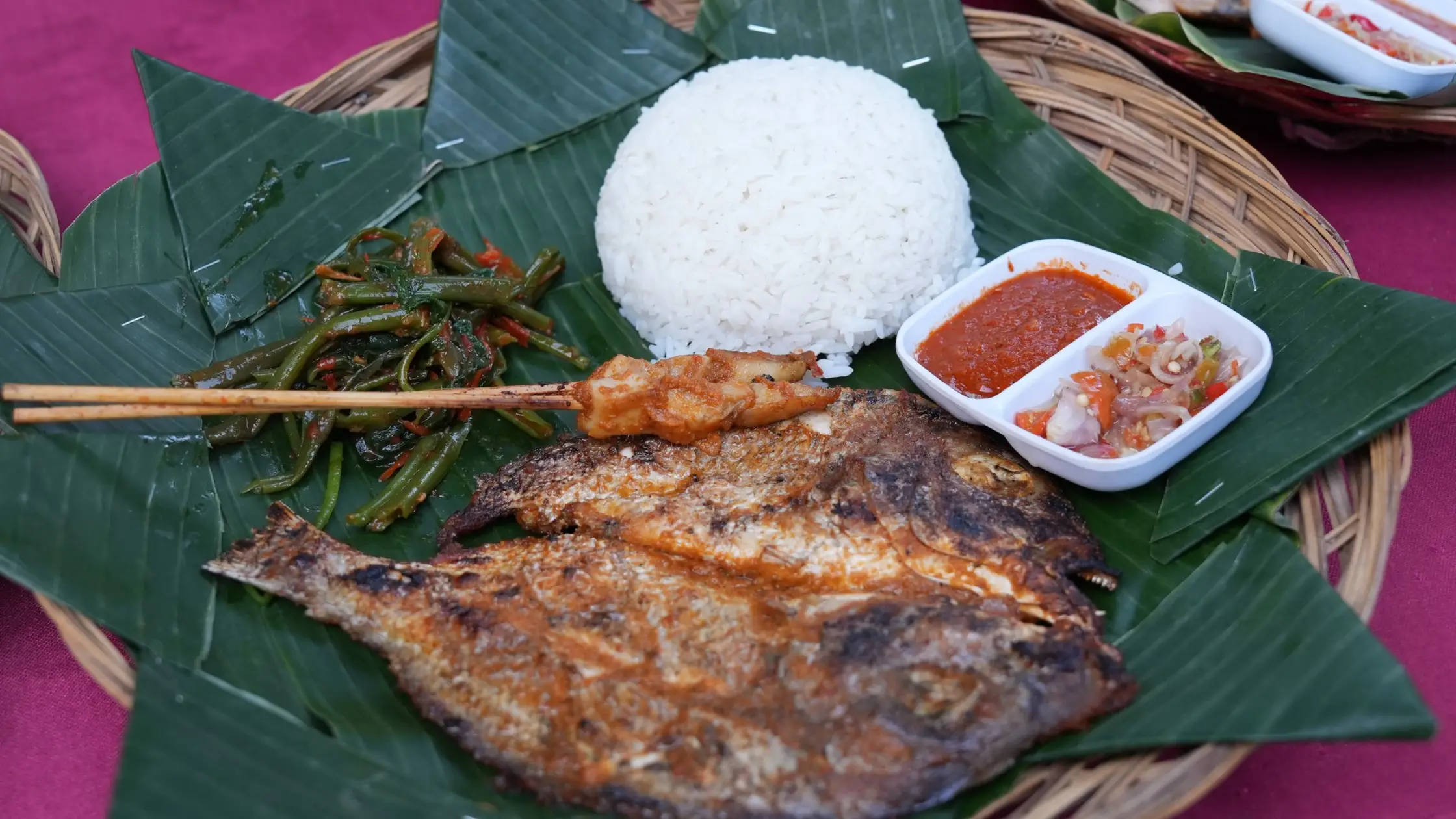 Balinese grilled fish with rice and sambal served on banana leaf