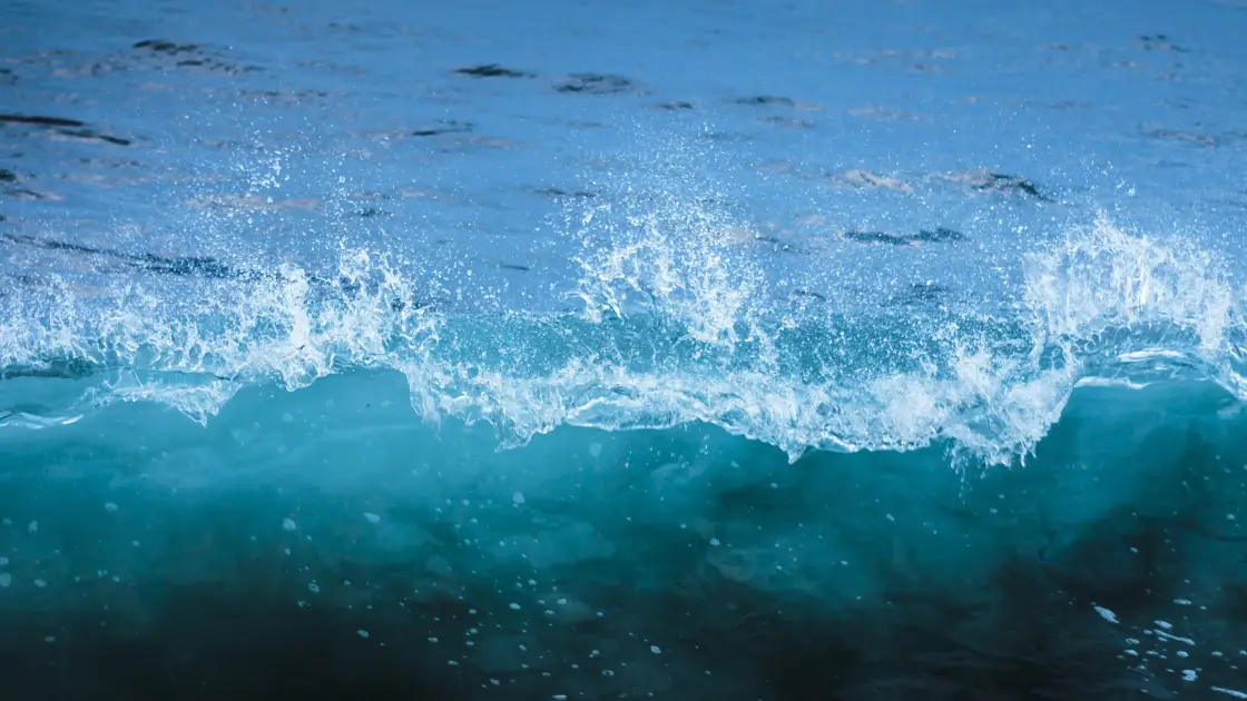 Blue ocean wave splashing with clear sea water