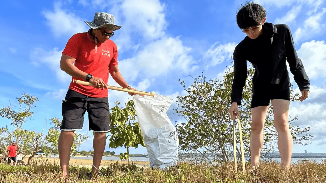Eco-conscious tourists volunteering in a Bali beach cleanup for sustainable travel & tourism