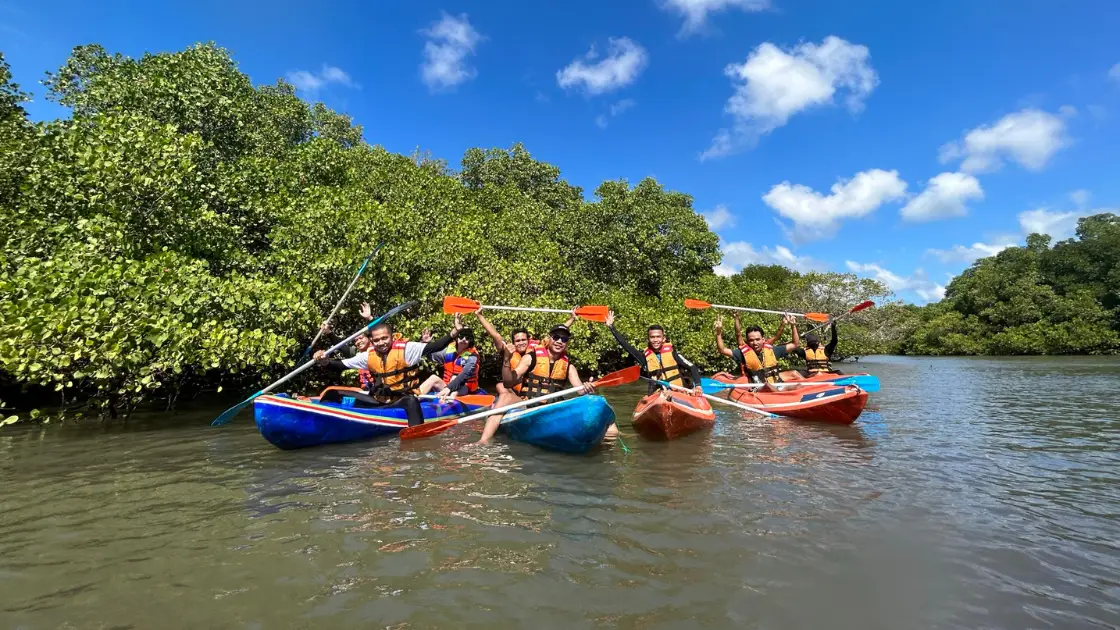 Small group paddling through calm mangrove waters during Bali Mangrove Adventure canoeing tour